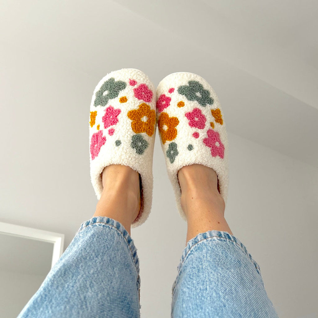White floral slippers on feet.