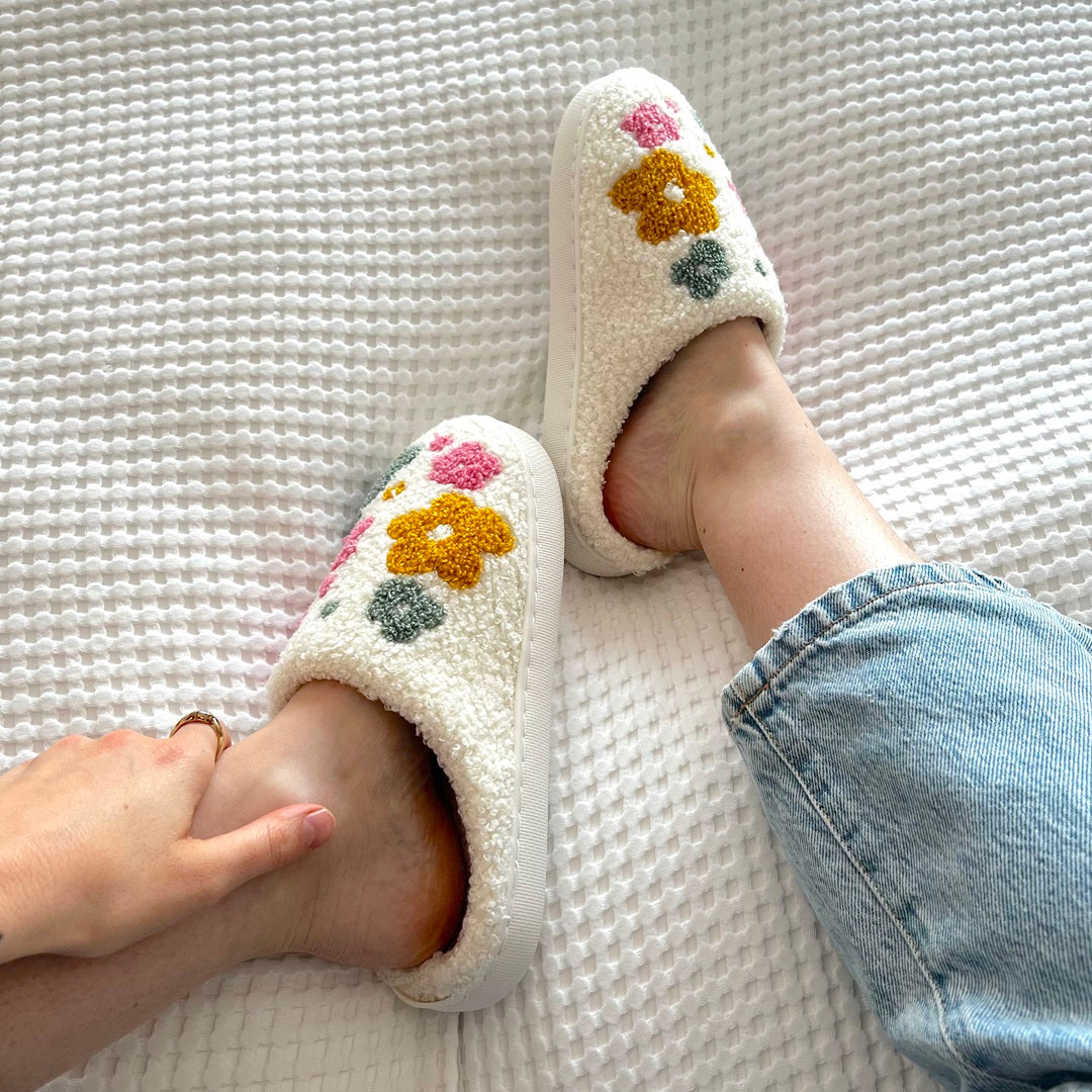 Floral embroidered slippers on bed